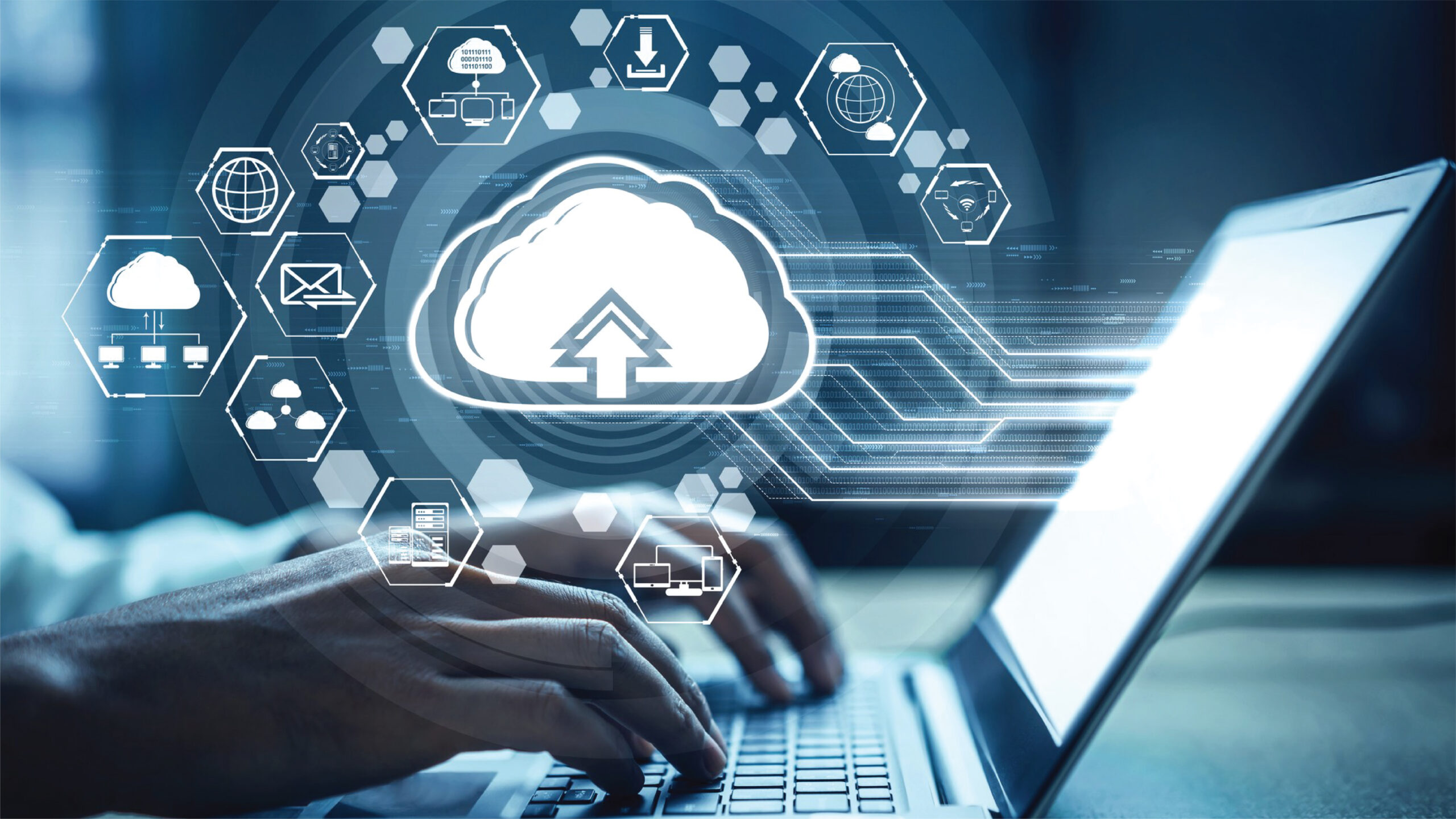 A cloud computing concept with a cityscape inside, symbolizing scalability, flexibility, faster development and deployment, improved fault isolation, and easier maintenance and updates. A person typing on a laptop with a cloud symbol surrounded by various digital icons, representing cloud computing and data storage.